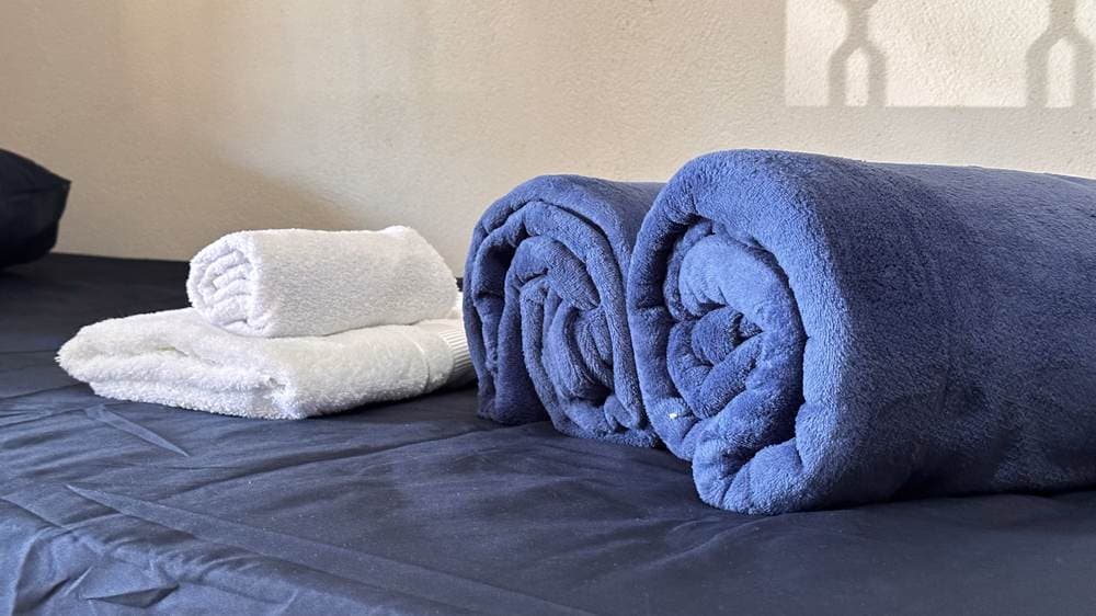 Toalhas e cobertores preparados sobre a cama